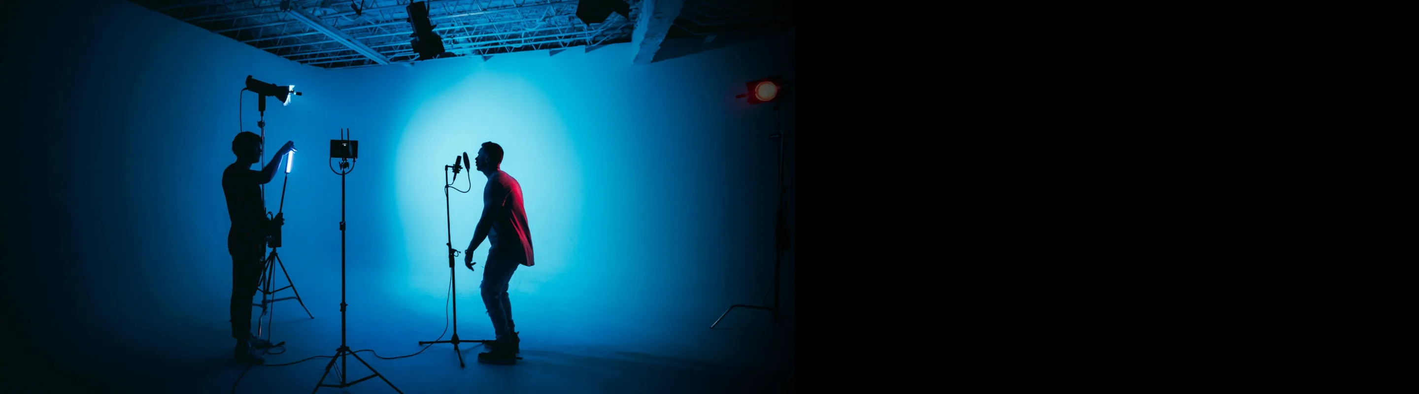 professional camera shooter capturing a music performance in a blue black room